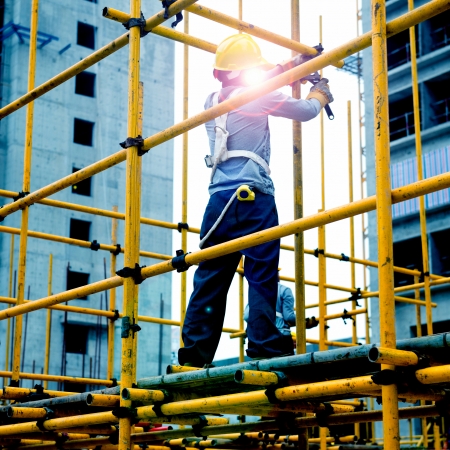 Construction workers working on scaffoldingの写真素材