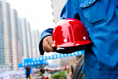 Worker holding a helmet with background of  blurred construction site.
の写真素材