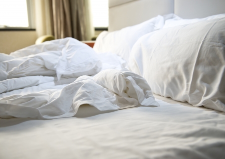 close up of messy bedding sheets and pillowの写真素材