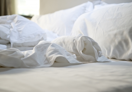close up of messy bedding sheets and pillowの写真素材