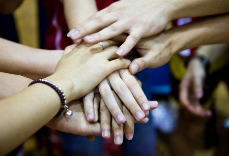 team of friends showing unity with their hands togetherの写真素材