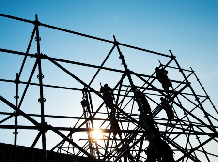 Construction workers working on scaffoldingの写真素材
