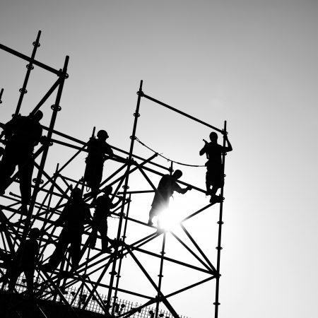 Construction workers working on scaffoldingの写真素材