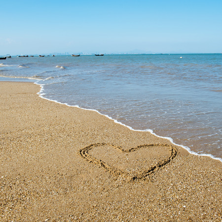 Single heart drawn on the sand of a beach.の写真素材