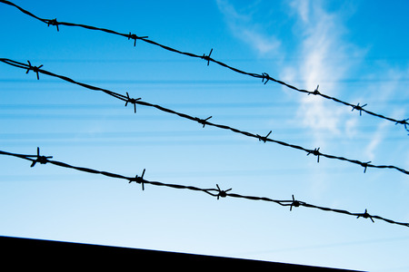 wire fence isolated on blue sky.の写真素材