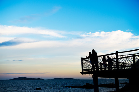 Man and woman enjoying the sea together at sunset.の写真素材