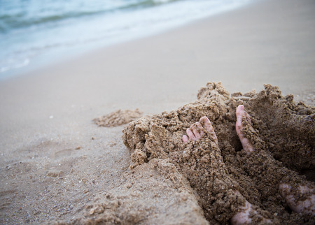 wet boy's feet on the beach and sandの写真素材