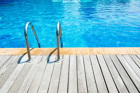 Swimming pool with stair and wooden deck at hotel.の写真素材