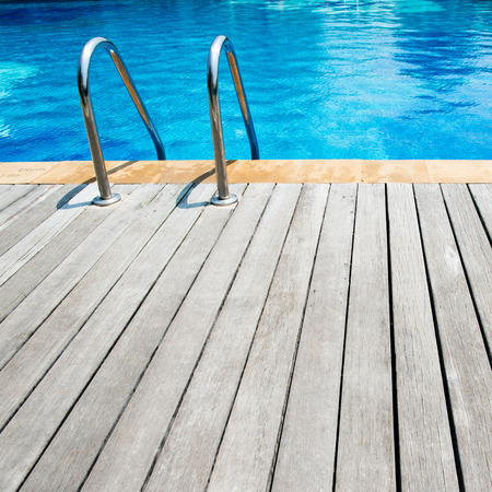 Swimming pool with stair and wooden deck at hotel.の写真素材