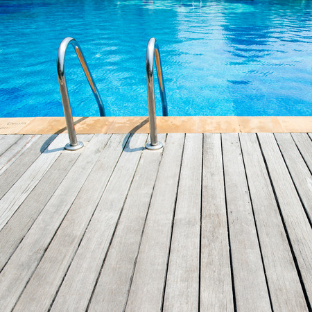 Swimming pool with stair and wooden deck at hotel.の写真素材