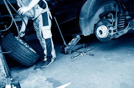 mechanic hands with tool repairing the car at garage.の写真素材