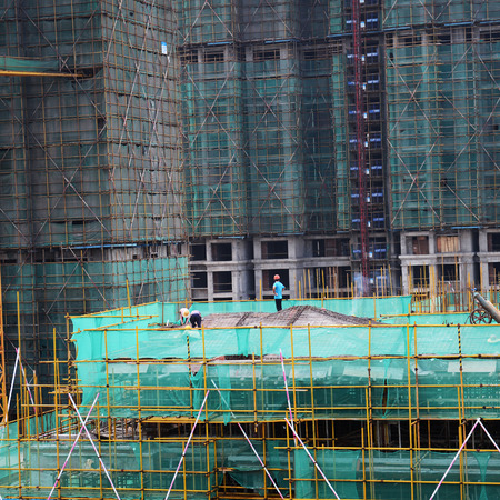Construction workers working on scaffoldingのeditorial素材