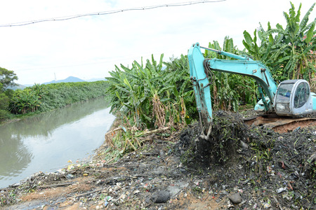 Excavator service in the polluted river.の写真素材
