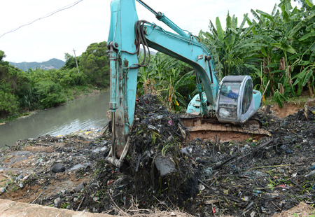 Excavator service in the polluted river.の写真素材