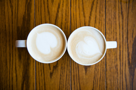 two cups of coffee cappuccino with heart shapeの写真素材
