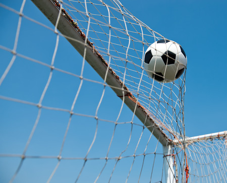soccer ball in goal. isolated on blue sky backgroundの写真素材