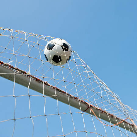 soccer ball in goal. isolated on blue sky backgroundの写真素材