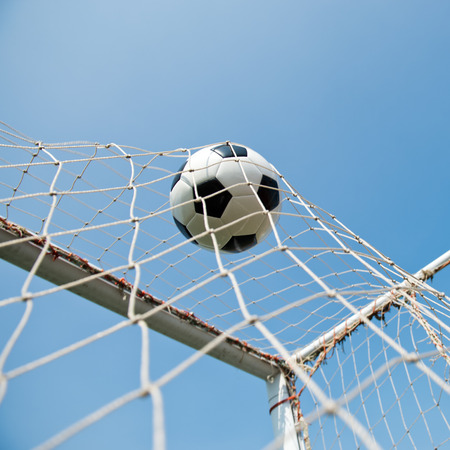 soccer ball in goal. isolated on blue sky backgroundの写真素材