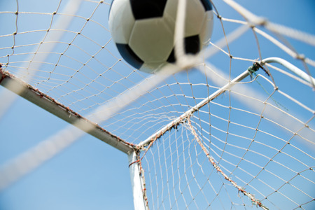 soccer ball in goal. isolated on blue sky backgroundの写真素材
