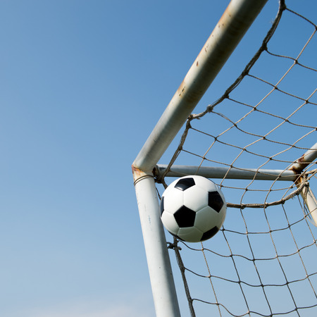 soccer ball in goal on the blue sky background.の写真素材