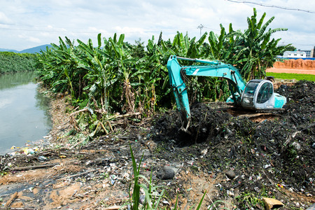 Excavator service in the polluted river.の写真素材