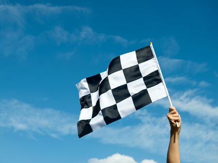 checkered race flag in hand.の写真素材