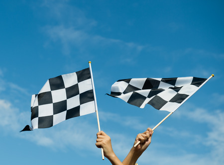 checkered race flag in hand.の写真素材