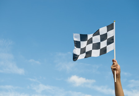checkered race flag in hand.の写真素材