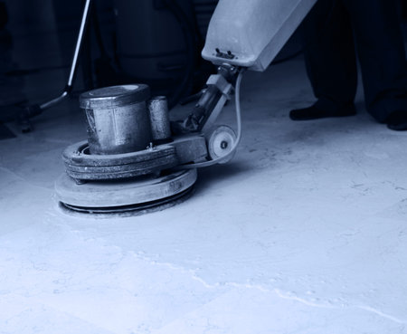 People cleaning floor with machine.