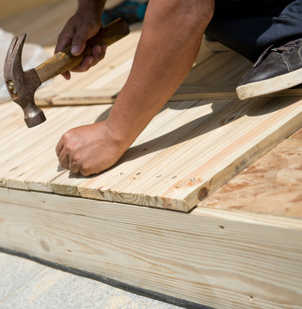 Man laying laminate flooring with tools.の写真素材