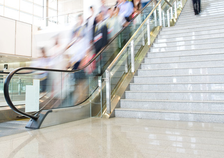 Group of businesspeople moving down on escalator in office. blurred motion.のeditorial素材