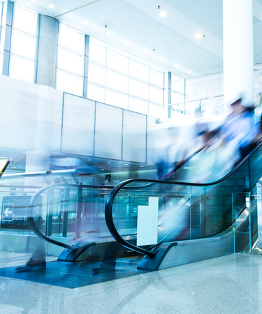 Group of businesspeople moving down on escalator in office. blurred motion.のeditorial素材