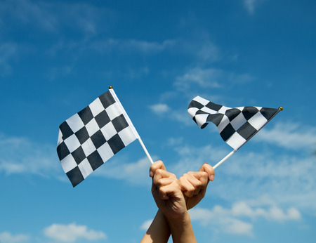 checkered race flag in hand.の写真素材