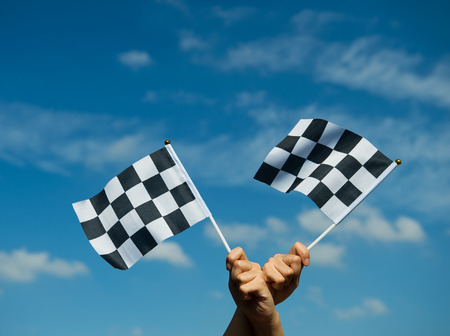 checkered race flag in hand.の写真素材