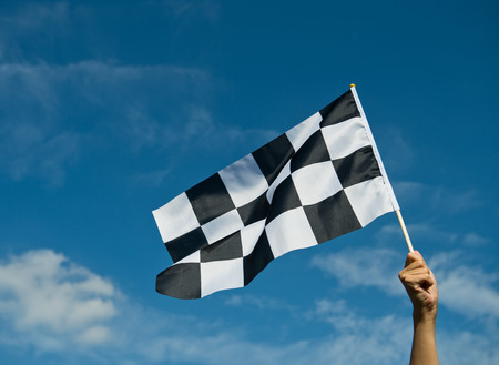 checkered race flag in hand.の写真素材