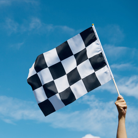 checkered race flag in hand.の写真素材