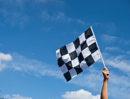 checkered race flag in hand.の写真素材