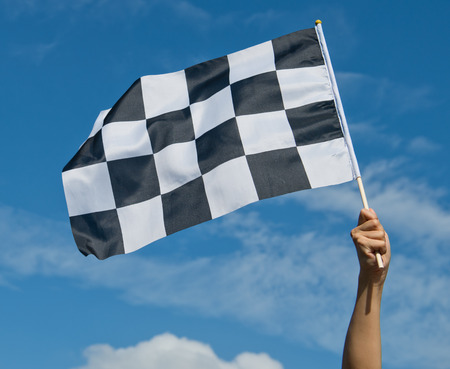 checkered race flag in hand.の写真素材