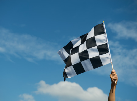 checkered race flag in hand.の写真素材
