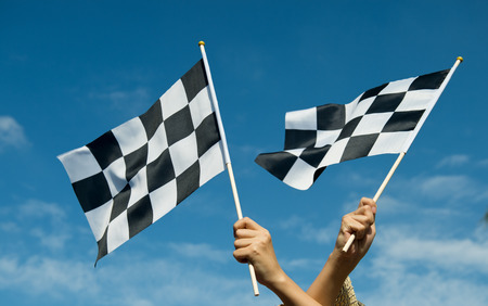 checkered race flag in hand.の写真素材