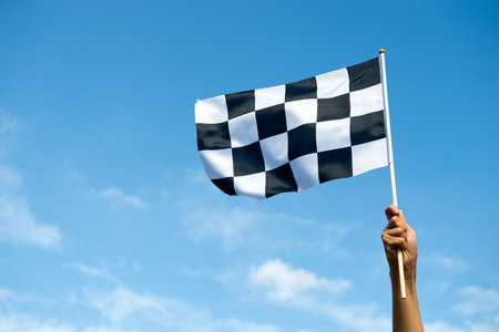 checkered race flag in hand.の写真素材