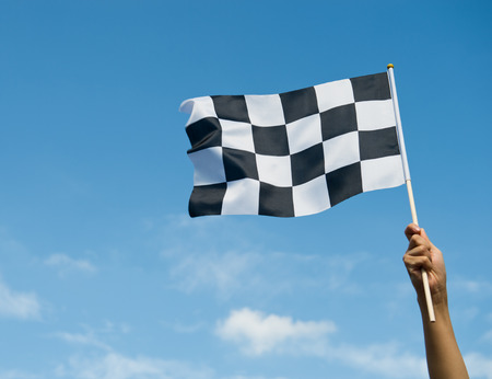 checkered race flag in hand.の写真素材