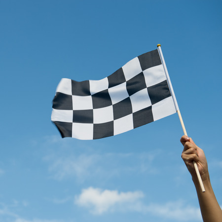 checkered race flag in hand.の写真素材