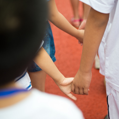 Group of children holding hands together.の写真素材