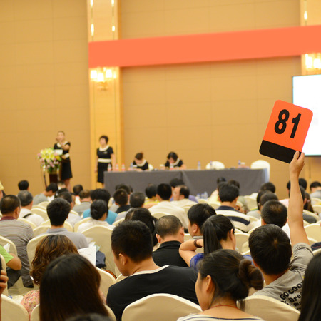 People holding auction paddle to buy from auction.の写真素材