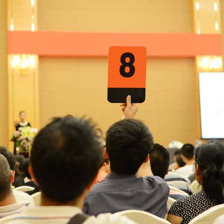 People holding auction paddle to buy from auction.の写真素材
