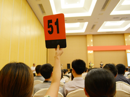 People holding auction paddle to buy from auction.の写真素材