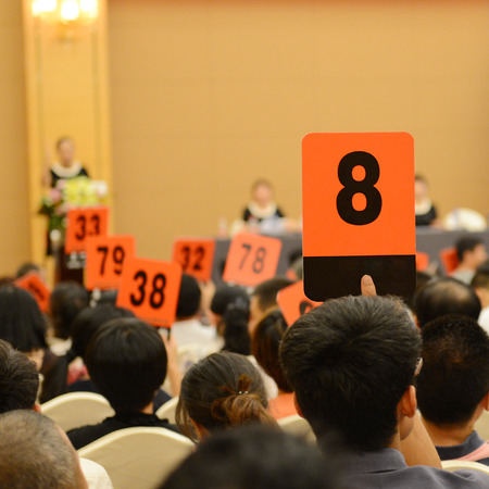 People holding auction paddle to buy from auction.の写真素材