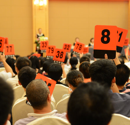 People holding auction paddle to buy from auction.の写真素材