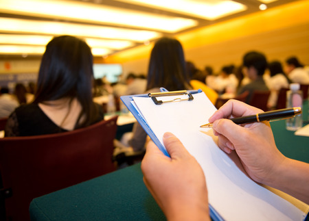 people writing on the document in a business seminar.の写真素材